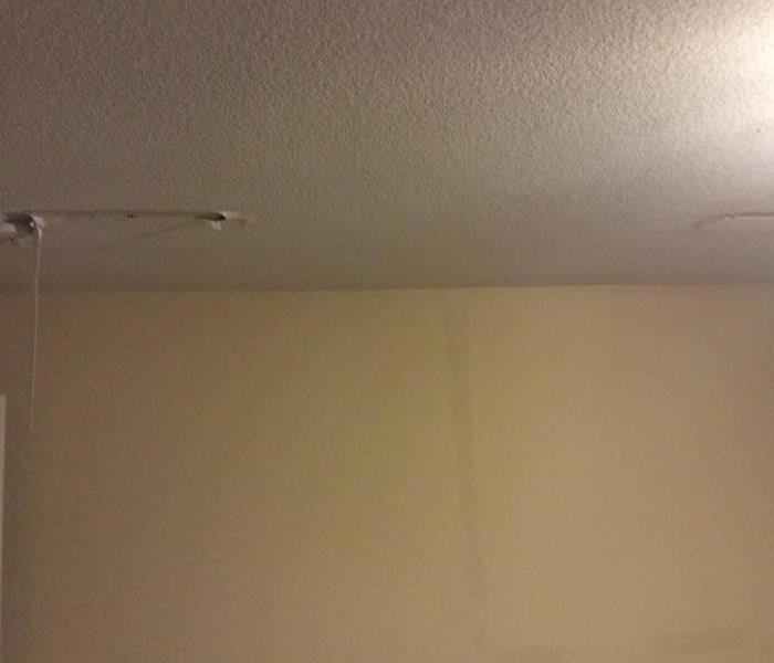 Light yellow wall with a dark water stained strip going down it. 